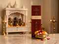 Grand Bouquet incense box standing before a white temple shrine, with a bowl of mixed flowers